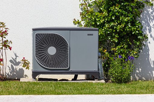 Eine Wärmepumpe im Vorgarten eines Hauses.